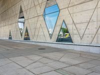 the entrance to an empty building has several large windows reflecting it's surroundings across the street