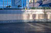 a parking lot in the middle of a city area with buildings reflected on glass wall