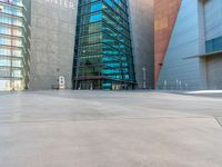 some very tall buildings with lots of windows and silver concrete tiles on the ground of a square concrete floor