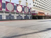 there are two people walking down the street in front of a movie theater building and theater across from it