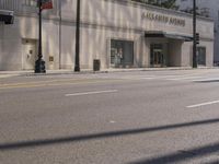 the entrance to the building is on the street corner next to the sidewalk of the street