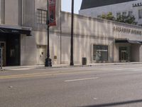 the entrance to the building is on the street corner next to the sidewalk of the street