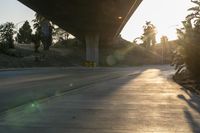 a view of an intersection on a sunny day with the sun shining on it and trees