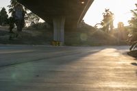 a view of an intersection on a sunny day with the sun shining on it and trees