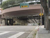 a yellow bicycle sits parked under a bridge in an empty city space for pedestrians and pedestrians