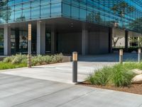 two grey blocks sitting next to a tall building on a sidewalk in front of grass