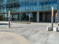 two grey blocks sitting next to a tall building on a sidewalk in front of grass