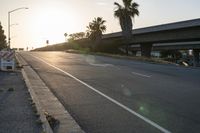 an empty street in a city at sunset with an overpass above the highway to allow traffic