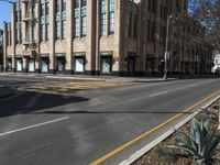 empty streets with stop lights on each side of them in the afternoon and a light pole on one end