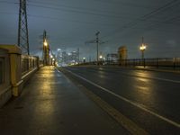 night photo of city lights and empty road at dusk with train passing in background at large metropolitan area