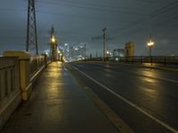 night photo of city lights and empty road at dusk with train passing in background at large metropolitan area