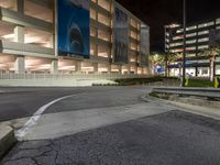 this is an empty parking garage at night time with its lights on and the road