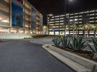 this is an empty parking garage at night time with its lights on and the road