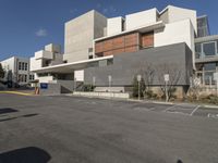 the building is empty and white in color, with concrete blocks behind it and on the street