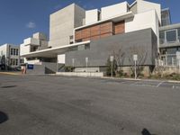 the building is empty and white in color, with concrete blocks behind it and on the street