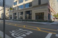 the yellow lines at an intersection in front of a building with windows on it's side