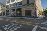 the yellow lines at an intersection in front of a building with windows on it's side