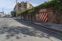 a city street with a long row of buildings lining it, including an iron bike rack on a sidewalk