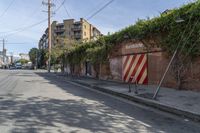 a city street with a long row of buildings lining it, including an iron bike rack on a sidewalk