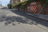 a city street with a long row of buildings lining it, including an iron bike rack on a sidewalk