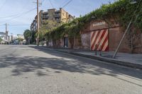 a city street with a long row of buildings lining it, including an iron bike rack on a sidewalk