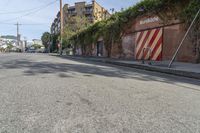 a city street with a long row of buildings lining it, including an iron bike rack on a sidewalk