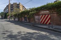 a city street with a long row of buildings lining it, including an iron bike rack on a sidewalk