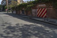 a city street with a long row of buildings lining it, including an iron bike rack on a sidewalk