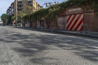 a city street with a long row of buildings lining it, including an iron bike rack on a sidewalk