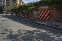 a city street with a long row of buildings lining it, including an iron bike rack on a sidewalk