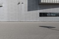 the building is covered in white corrugated panels and a red fire hydrant sitting outside