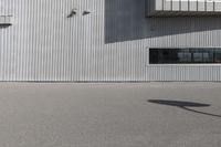 the building is covered in white corrugated panels and a red fire hydrant sitting outside