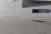 the building is covered in white corrugated panels and a red fire hydrant sitting outside