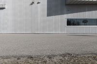 the building is covered in white corrugated panels and a red fire hydrant sitting outside