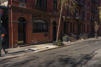 a street with brick buildings next to a white car on a street side walk in the city