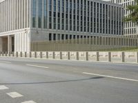 an empty street next to large buildings with windows and pillars on each side of them