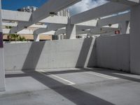 an empty parking lot has some sun casting onto the wall and windows above it with no shadows