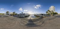 a fish eye view looking into a dock in the middle of water with buildings and tall buildings