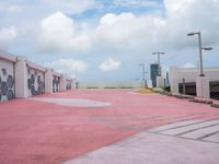 a very pink parking lot with a sign on it and lots of building windows with the doors opened