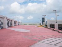 a very pink parking lot with a sign on it and lots of building windows with the doors opened