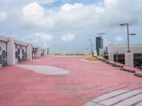 a very pink parking lot with a sign on it and lots of building windows with the doors opened