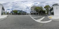 a 360 lens photograph of a street with buildings and trees at a distance, taken from an angle