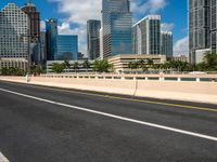 the road runs down to the street, which is lined with buildings and skyscrapers