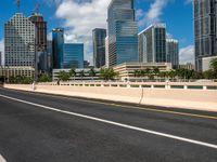 the road runs down to the street, which is lined with buildings and skyscrapers