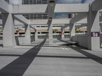 a photo of a parking lot with a sky scraper behind the area and street sign