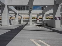 a photo of a parking lot with a sky scraper behind the area and street sign