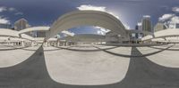 a curved sculpture in a city that is made up of a circular frame with a sky background