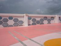 red, white and gray patterns on a roof of a building with a white fence