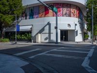 a crosswalk in front of an art gallery with a mural on the side of the building