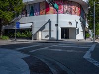 a crosswalk in front of an art gallery with a mural on the side of the building